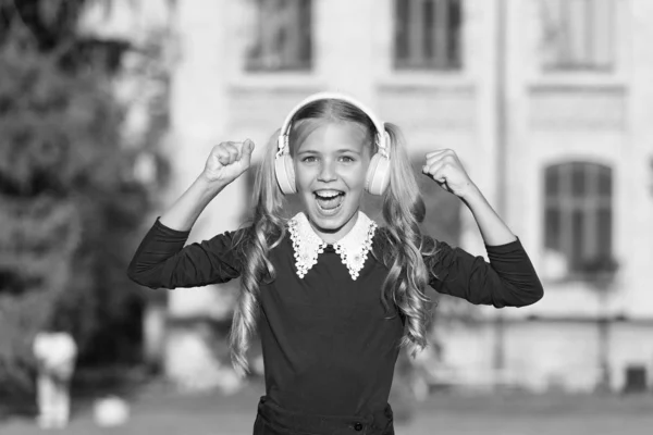 Adorable kid using modern technology. Modern child. Perfect sound. Expand opportunities. Inspired by music. Girl listening music modern gadget. Cute kid with wireless headset. Stereo headphones — Stock Photo, Image
