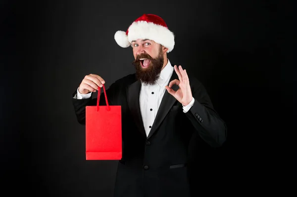 Τέλειο δώρο. Ευτυχής επιχειρηματίας δείχνουν OK σημάδι. Ένας γενειοφόρος χαμογελάει με δώρο στην τσάντα. Ψώνια για Χριστουγεννιάτικο δώρο. Ημέρα πυγμαχίας. Πρωτοχρονιάτικη έκπληξη. Πάρτι γραφείου. Δώρο από το αφεντικό στους εμπόρους, αντίγραφο χώρου — Φωτογραφία Αρχείου