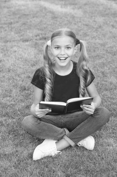 Está na hora de grandes histórias. Criança a ler livros ao ar livre. Estudante ler histórias enquanto relaxa gramado verde. Aluno bonito gosta de ler. Hora da escola. Histórias interessantes para crianças. Estudo com prazer — Fotografia de Stock