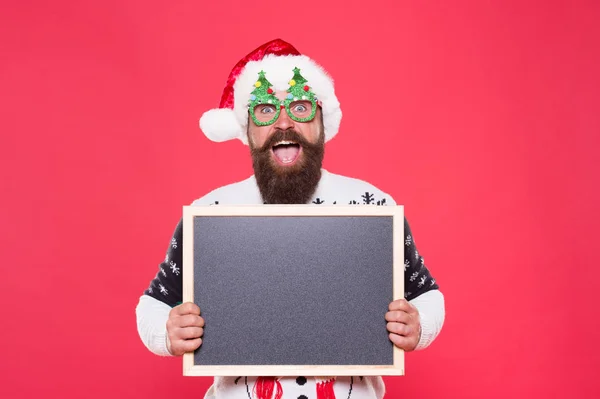 Inverno calo dei prezzi. L'hipster barbuto Babbo Natale. Gioioso uomo mostra lavagna spazio copia. Buone vacanze invernali. Presentazione o annuncio. Promozione di beni e servizi invernali. Concetto noleggio sci — Foto Stock