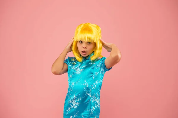 일본의 기모노. 일본의 어린이 민속 의상. 동양 전통의 작은 소녀. 동양인 여자노란 머리 가발. 중국식 카니발. 분홍색 배경 사진을 찍은 아이입니다. 때리는 파스텔 — 스톡 사진