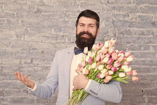 Ausdruck von Positivität. glücklicher Frauentag. Blume für 8. März Frühlingsgeschenk. glücklicher bärtiger Mann Hipster mit Blumen, Kopierraum. bärtiger glücklicher Mann mit Tulpenstrauß. Liebesdatum. frohe Feiertage — Stockfoto