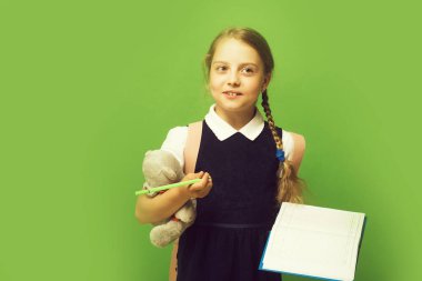 Kurnaz yüzlü, örgülü, yeşil elbiseli liseli kız.