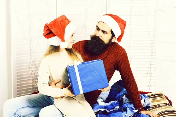Santa άνθρωπος με ξανθιά κοπέλα n μπεζ φόρεμα κάθεται στα γόνατα του όμορφος γενειοφόρος άνδρας. — Φωτογραφία Αρχείου