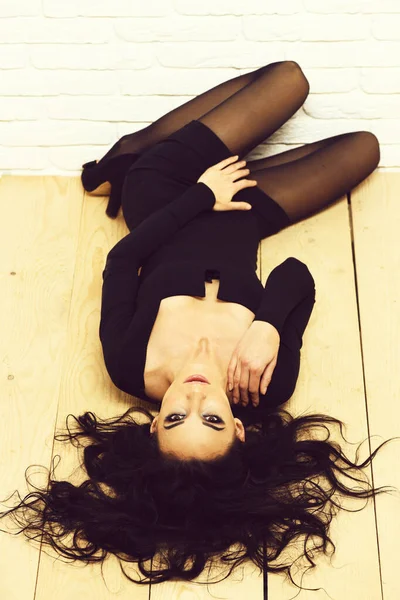 Sexy menina em vestido preto no chão de madeira fundo — Fotografia de Stock