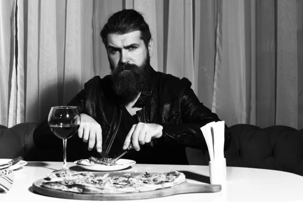 Bıçak ve çatalla pizza yiyen sakallı adam. — Stok fotoğraf