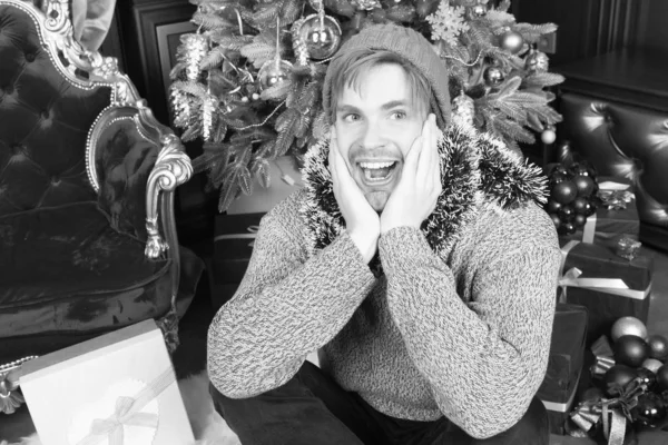 Homem com cara feliz sentar na árvore de xmas no quarto — Fotografia de Stock