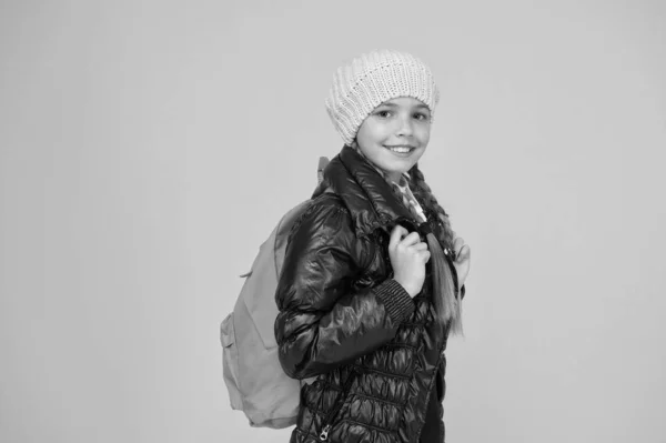 Rugzak voor het veilig houden van spullen onderweg. Kleine kinderen dragen schoolrugzak op gele achtergrond. Klein meisje met rugzak op herfstvakantie. Haar rugzak is zo praktisch als schattig. — Stockfoto