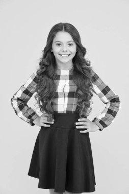 Okul zamanlarında ona göz kulak ol. Resmi moda tarzında mutlu küçük kız. Uzun kıvırcık saçlı şirin bir çocuk gülüşü. Okul üniforması asla demode olmaz. Okul kıyafet kuralı.