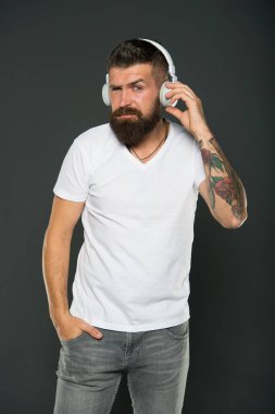 Güzel melodiler. Hippi müzik kulaklığıyla müzik dinler. Sakallı adam kulaklık takıyor. Modern kulaklıklar kullanarak. Temiz ses getirmek için tasarlanmış kulaklıklar.