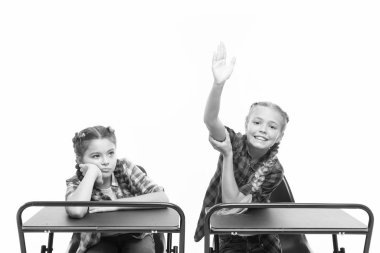 Çalışma sürecinin keyfini çıkarın. Öğrenciler sınıf arkadaşları masa başında. Okula geri dön. Özel okul konsepti. İlkokul eğitimi. Küçük kızlar okul arkadaşları birlikte çalışır. Cevap vermek için el kaldırın