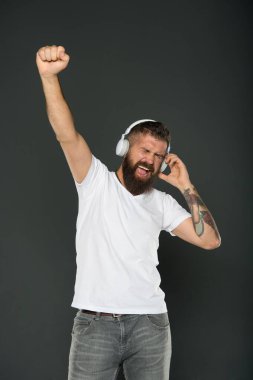Her zaman kazanır. Mutlu kazanan müzikle kutlar. Kulaklık takan sakallı adam çok iyi bir jest yapıyor. Duygusal hipster, müziğin gri arka planını dinle. Zaferi kutluyoruz. Kazanan asla pes etmez.
