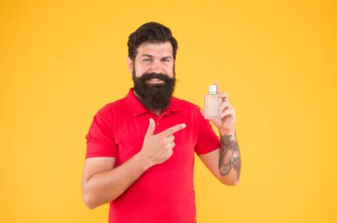 Losyon spreyi. Parfüm ürünleri konsepti. Sakallı, yakışıklı adam şişe parfümü kullanıyor. Parfüm sürmüş. Misk kokulu madde, genelde temel notalarda kullanılır. Parfümü duruma göre seç