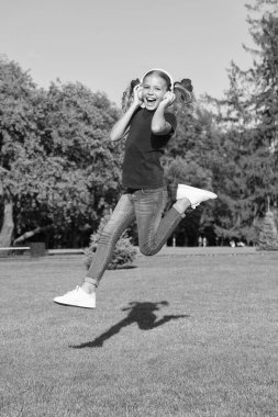 Aktif ve dinamik. Aktif çocuk yeşil çimlerin üzerinden atlıyor. Mutlu küçük kız müziğe aktiftir. Enerjik küçük çocuk kulaklıkla müzik dinliyor. Aktif ve mutlu. Yaz tatili