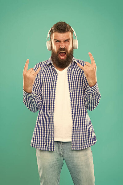 Heavy metal and hard rock. Streaming music sites. Wireless technology. User friendly interface and large library of tunes. Hipster with beard listening music. Handsome music lover. Man in headphones