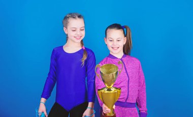 genç kız zaferi. Akrobasi ve jimnastik. Küçük kızlar ip atlama tutun. Yarışmada kazanan. Spor başarı. Mutlu çocuk altın şampiyon Kupası ile. zor iş ödül getiriyor. ödül motivasyon