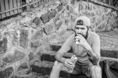 Adam sakallı hızlı atıştırmalık tadını çıkarın. Sokak yemekleri çok güzel. Kentsel yaşam tarzı ve sağlıksız beslenme. Kaygısız hipster merdivenlerde oturup abur cubur yer. Aç adam atıştırması. Abur cubur. Sosisli yiyen adam