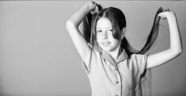 Beauty tips for tidy hair. Innocence concept. Happy childrens day. Pure beauty. Girl long healthy shiny hair close up. Little girl with long hair. Kid cute face with adorable hair on pink background