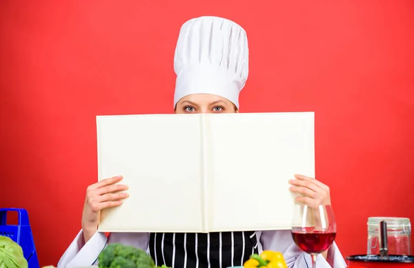 Cook ψάχνει για συνταγή μαγειρικής στο βιβλίο μαγειρικής. Γυναίκα διαβάζει βιβλίο μαγειρικής στην κουζίνα. Κορίτσι μαγειρεύουν στα συστατικά τραπέζι της κουζίνας. Συμβουλές και συμβουλές. Ετοιμάζω φαγητό. Νόστιμο και γκουρμέ. Μαγείρεμα τροφίμων ως χόμπι — Φωτογραφία Αρχείου