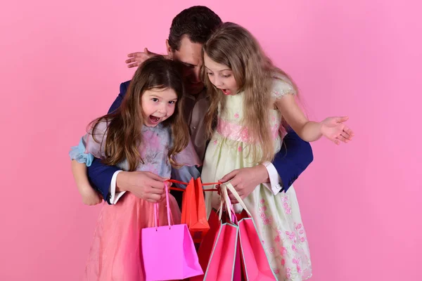 Compras e apresenta conceito. Meninas e homem com rostos surpresos — Fotografia de Stock