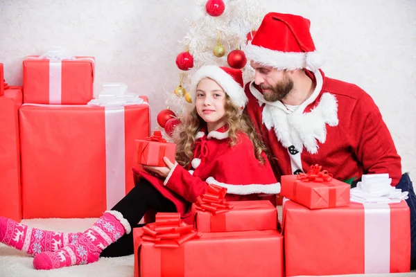 クリスマスのコンセプト。家族のクリスマスお祝いの伝統。かわいい娘とサンタの衣装のお父さんは一緒にクリスマスを祝います。牧歌的な瞬間だ。幸せな子供時代。クリスマス家族の休日 — ストック写真