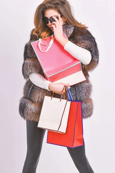 Shopping with promo code. Girl wear sunglasses and fur coat shopping white background. Lady hold shopping bags. Discount and sale. Woman shopping luxury boutique. Buy with discount on black friday — Stock Photo, Image