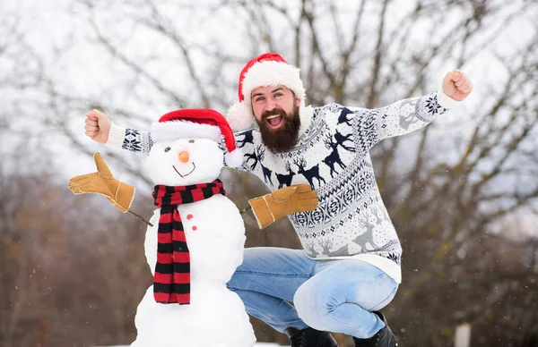 Ο γενειοφόρος φτιάχνει χιονάνθρωπο. Ευτυχισμένος χίπστερ έτοιμος να γιορτάσει Χριστούγεννα. χειμερινή περίοδο δραστηριότητας. Ο 'γιος Βασίλης παίζει με το χιόνι. χειμερινές διακοπές υπαίθρια. ζεστό πουλόβερ σε κρύο καιρό. Χριστούγεννα του — Φωτογραφία Αρχείου