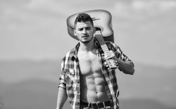 Make my day. hipster fashion. western camping and hiking. happy and free. cowboy man with bare muscular torso. acoustic guitar player. country music song. sexy man with guitar in checkered shirt