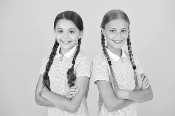 Back to school. happy beauty with pigtails. happy childhood. brunette and blond hair. sisterhood concept. best friends. vintage style. small girls in retro uniform. old school fashion. fashion model — Stock Photo, Image
