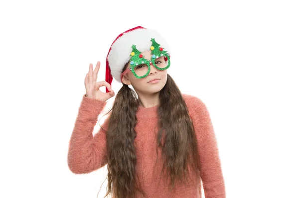 Just perfect. Little santa. Christmas event and entertainment. Happy about new year. Christmas holiday. Small girl in santa hat. Having fun. Happy child christmas tree eyewear accessory booth props — Stock Photo, Image