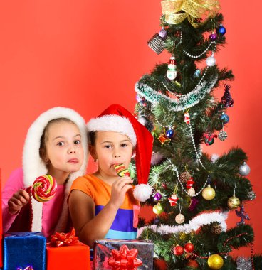 Noel Baba şapkalı kız kardeşler hediye kutularını açtılar.