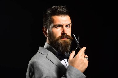 Resmi takım elbiseli maço sakal ve bıyık kesiyor..