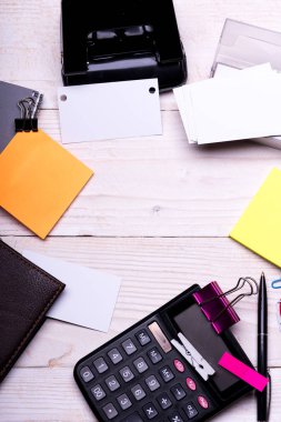 Boş alanlı kartvizit ve yapışkan notların yanında klasörler.