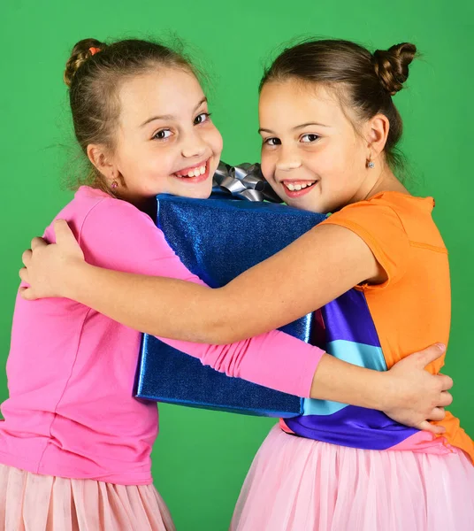 Les enfants embrassent cadeau bleu pour Noël. Sœurs avec boîte cadeau — Photo