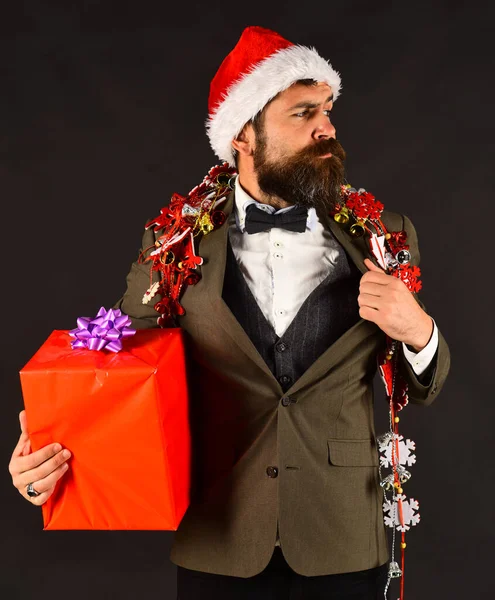 Gerente com barba detém presente vermelho. Conceito de decorações de Ano Novo . — Fotografia de Stock