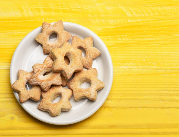 Biscoitos em forma de estrela deitados na placa branca. Pastelaria caseira — Fotografia de Stock