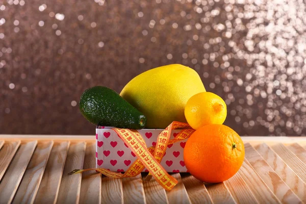 Frutas en caja con patrón de corazones en superficie de madera . — Foto de Stock