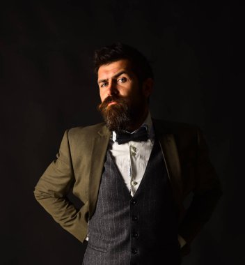 Eskimiş şık takım elbiseli ve kahverengi arka planda yelek giyen adam.