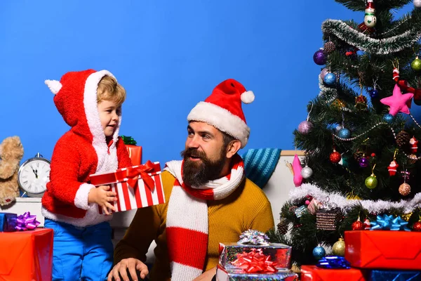 Weihnachtsmann und kleiner Helfer zwischen Geschenkboxen am Weihnachtsbaum. — Stockfoto