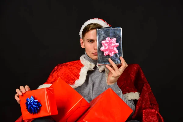Санта с подарками на черном фоне. Человек показывает половину лица — стоковое фото