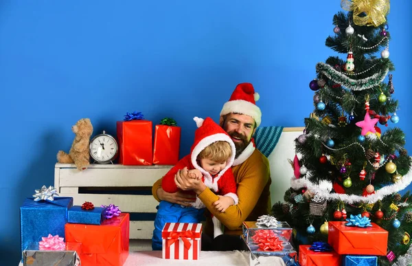 크리스마스 트리 근처 선물 상자 안에 있는 산타와 작은 조수. — 스톡 사진