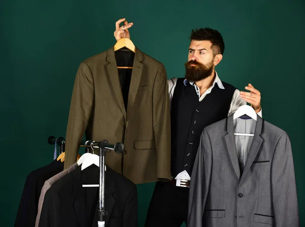 Homem com barba na prateleira das roupas. Moda de negócios e compras — Fotografia de Stock