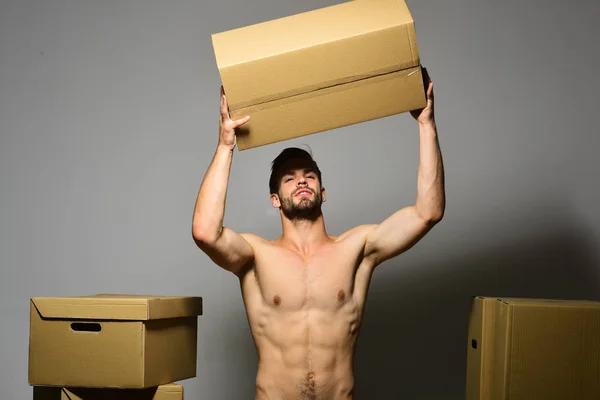 Cargador con torso desnudo sexy sostiene la caja por encima de la cabeza —  Fotos de Stock