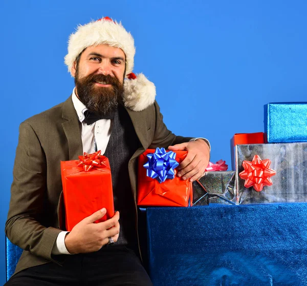 Santa σε ρετρό κοστούμι παρουσιάζει μπλε και κόκκινα δώρα. — Φωτογραφία Αρχείου