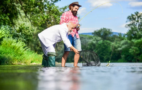 Concepto familiar feliz. Concepto de captura y pesca. Dos amigos pescando juntos. pasatiempo pez mosca de hombre de negocios. pesca de jubilación. feliz amistad de pescadores. padre jubilado e hijo maduro —  Fotos de Stock