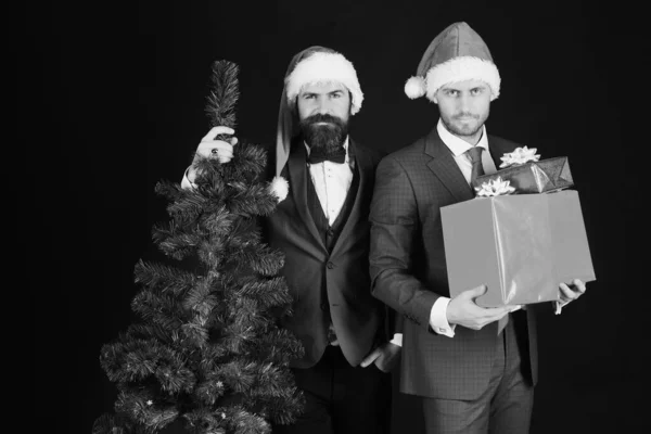 Hombres en trajes inteligentes y sombreros de Santa sobre fondo marrón — Foto de Stock