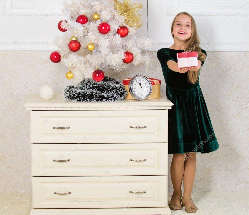 Kid girl near christmas tree hold gift box. Time to open christmas gifts. Merry christmas concept. Dreams come true. Best for our kids. Child celebrate christmas at home. Favorite day of the year