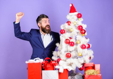 Noel hazırlığı ve kutlaması. Sakallı hippi adam Noel ağacının yanında resmi takım elbise giyer. Noel hediyeleri ve dekorasyonlar. Harika bir ofis noel partisi nasıl düzenlenir. Kutlamaya hazır.
