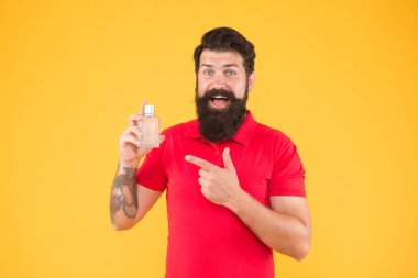 Parfüm seç. Losyon spreyi. Parfüm ürünleri konsepti. Sakallı, yakışıklı adam şişe parfümü kullanıyor. Parfüm sürmüş. Misk aromatik madde genellikle temel notada kullanılır.