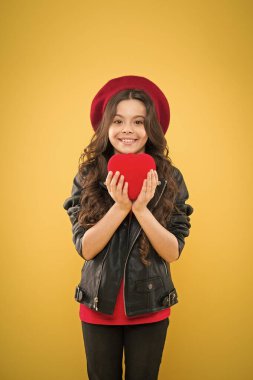 Romantik bir ruh hali. Kalbimle oynama. Sevgililer gününü kutla. Aşk konsepti. Kız sevimli çocuk göstermek kalp oyuncak. Aşkın kalp sembolü. Çocuk şık modern kız mutlu yüz göstermek kalp sarı arka plan